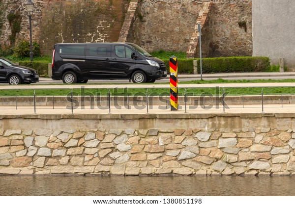 GÖRLITZ, GERMANY -\
APRIL, 2019: German border pillar near the Lusatian Neisse River\
that dividing the cities of Görlitz and Zgorzelec. Internal border\
of the European Union