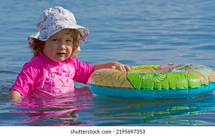 Germany, August 28, 2018: Toddler Playing Alone With A Swim Ring In The Lake