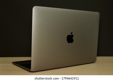 Münster, Germany- August/10/2020: Isolated Apple MacBook, Back, Notebook On Wooden Underground, Black Background, Apple Logo