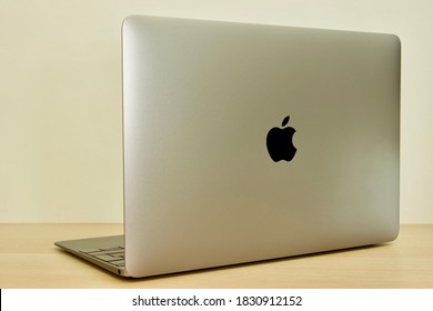 Münster, Germany- August/10/2020: Isolated Apple MacBook, Back, Notebook On Wooden Underground, White Background, Apple Logo