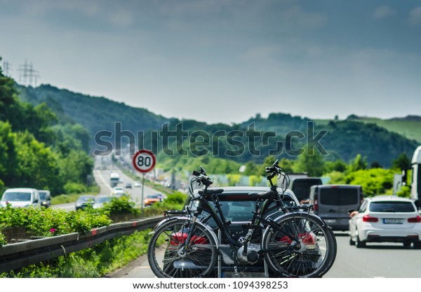 Germany Autobahn\
traffic. Car with bike\
rack.