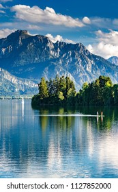 Germany, Bavaria, Allgaeu, Lake Forggensee With A Couple Standup Paddling