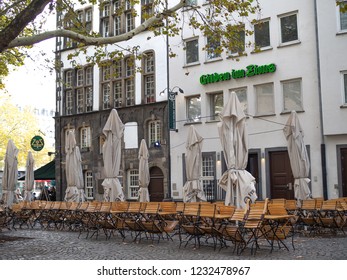 Germany, Cologne - October 2018. Sunny street, multicolored buildings, cozy cafes, city life. Open air cafe near downtown