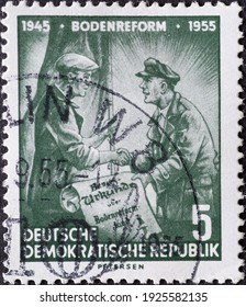 GERMANY, DDR - CIRCA 1955 : A Postage Stamp From Germany, GDR Showing A Farmer With A Flat Cap Who Receives His Deed Of Ownership After The Land Reform. Text: 10 Years Of Land Reform 