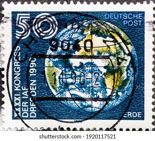 GERMANY, DDR - CIRCA 1990: A Postage Stamp From Germany, GDR Showing The Earth With Geographic Coordinates (latitude And Longitude) IAF = International Astronautical Federation
