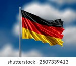 Germany flag flying on blur blue clouds background.