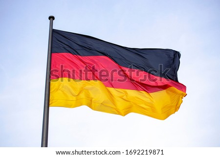 Germany flag waving in the wind close-up against a blue sky