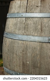 Germany. . Fragment Of An Old Wooden Vine Barrel With An Metall Hoop On A Dark Background. Wooden Barrel With Metall Straps. Wood Texture. Side View. Close-up. Macro. Copy Sp