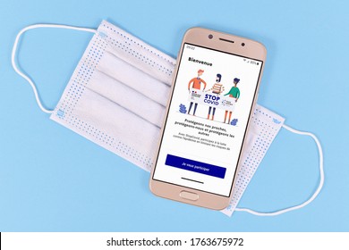 Germany - June 2020: Official French Corona Contact Tracing App Called 'Stop Covid France' On Mobile Phone With Face Mask On Blue Background