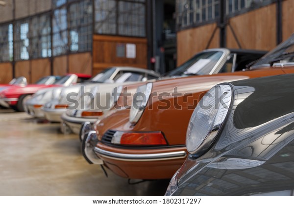 Düsseldorf, Germany - JUNE 2020: Selected focus\
at headlight and hood of group vintage luxury Porsche sport car at\
Classic Remise in Düsseldorf,\
Germany..