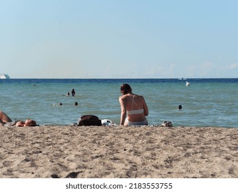 Warnemünde, Germany - June 28, 2022: Woman Tanning At The Beach In Tourist Hotspot Rostock-Warnemünde