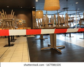 Tönisvorst, Germany - March 19. 2020: View Beyond Red White Don´t Cross Line In Empty Closed Restaurant With Chairs Stapled On Tables During Corona Crisis