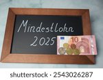 In Germany, the minimum wage will be increased to 12.82 euros in 2025 - the word minimum wage is written on the board in German