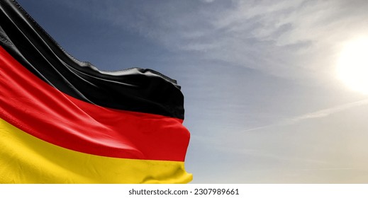 Germany national flag cloth fabric waving on beautiful grey sky Background. - Shutterstock ID 2307989661