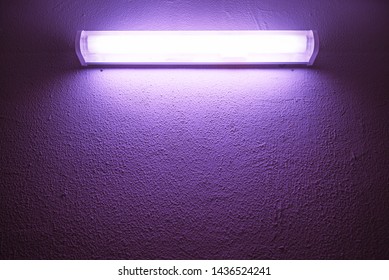 Germicidal Ultraviolet Lamp Glows On A Rough Wall