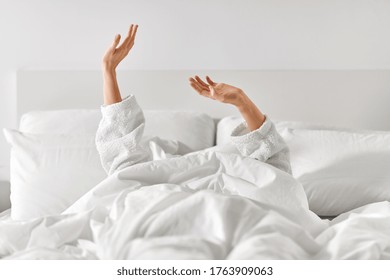 Gesture, Comfort And Morning Concept - Hands Of Young Woman In Hotel Robe Lying In Bed And Stretching At Bedroom