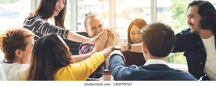 Gesture hand high five of Group employee laughing together with achivement mission at millenial company. Casual business with startup friends teamwork community celebration, win and conquest concept