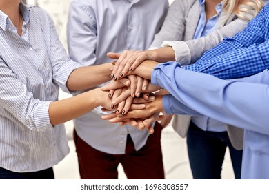 gesture, people and teamwork concept - close up of business team, friends or students stacking hands - Shutterstock ID 1698308557