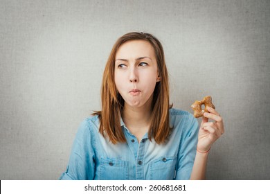 gesture woman eating cookies. isolated on gray background