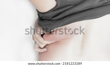 gesture of a woman holding a muscle The area behind her body with excess fat under her skin. on a white background