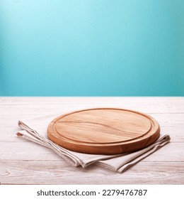 Get an exquisite experience with this high-quality wooden pizza board and napkin. Bread And Fruit Cutting Board and Blue pastel background top view mock up.