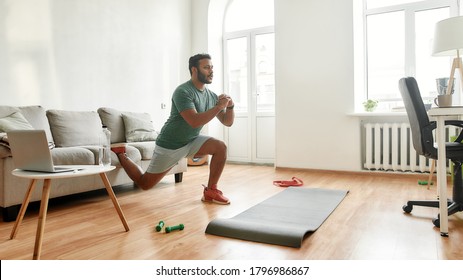 Get Fit At Home. Full Length Shot Of Young Active Man Watching Online Video Training On Laptop, Exercising, Stretching During Morning Workout At Home. Sport, Healthy Lifestyle. Web Banner