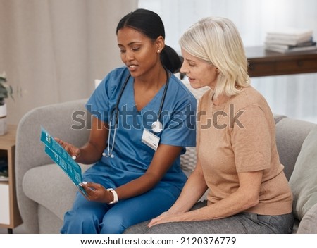 Get informed, make a good decision. Shot of a doctor reading a pamphlet about Covid-19 on the sofa at home.