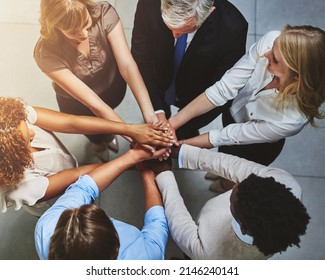 Get involved, get it done. High angle shot of a group of colleagues joining their hands in solidarity. - Shutterstock ID 2146240141
