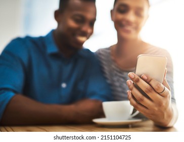 The Get To Know You Part Of The Date. Shot Of A Young Man And Woman Using A Mobile Phone Together On A Date At A Coffee Shop.