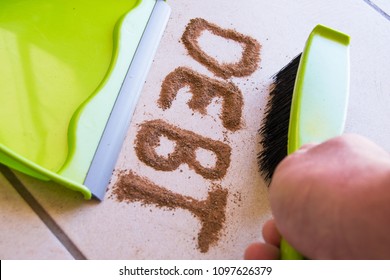 Get Rid Of Debt Concept With Debt Written In Dirt On A Floor And A Person Is About To Sweep The Debt Dirt In A Dust Pan Using A Small Hand Broom