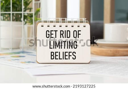 Get Rid Of Limiting Beliefs. text on wood table, on white paper.