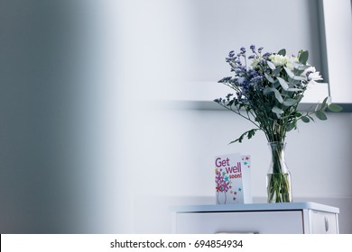 Get Well Soon Card With Flower Vase On Side Table In Hospital Ward.