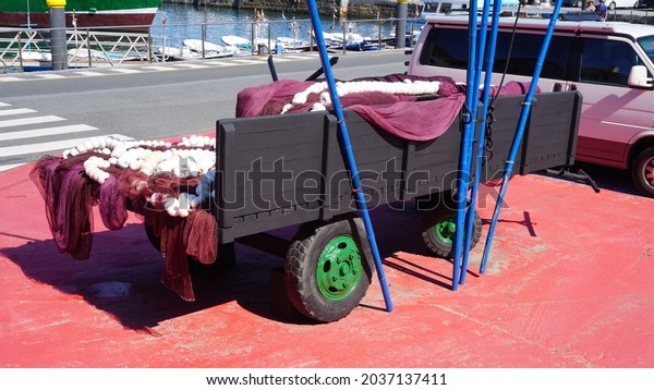 Getaria, Guipúzcoa, Basque Country, Spain,\
August, 20, 2021: Trailer with fishermen\'s nets and an anchor in\
the port of Getaria, in the Basque\
Country