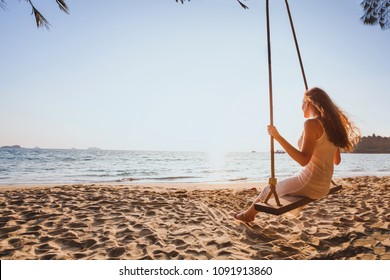 Getaway Dream And Happiness Concept, Romantic Beautiful Carefree Woman Relaxing On The Swing At Sunset Beach, Summer Holidays, Vacation Travel And Relaxation, Inspiring Landscape