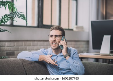 Getting Angry. Young Bearded Man In Blue Shirt Having A Tough Conversation