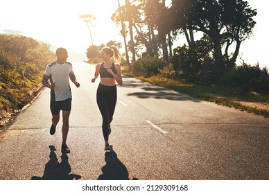 Getting The Blood Flowing With A Workout Buddy. Shot Of A Fit Young Couple Going For A Run Outdoors.