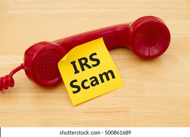 Getting A Call That Is An IRS Scam, A Retro Red Phone With Yellow Sticky Note On A Desk With Text IRS Scam