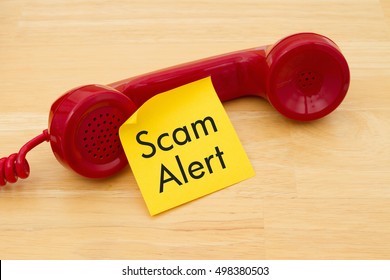 Getting A Call That Is An Scam, A Retro Red Phone With Yellow Sticky Note On A Desk With Text Scam Alert