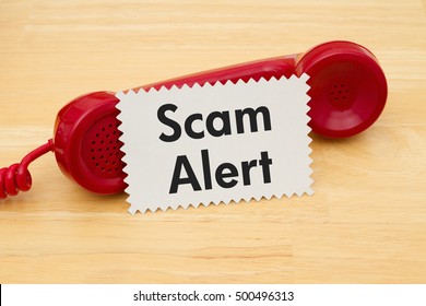 Getting A Call That Is An Scam, A Retro Red Phone With Note Card On A Desk With Text Scam Alert