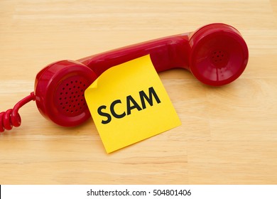 Getting A Call That Is An Scam, A Retro Red Phone With Yellow Sticky Note On A Desk With Text Scam