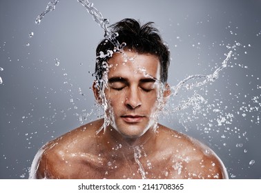 Getting Clean. A Young Man Splashing Water On His Face.