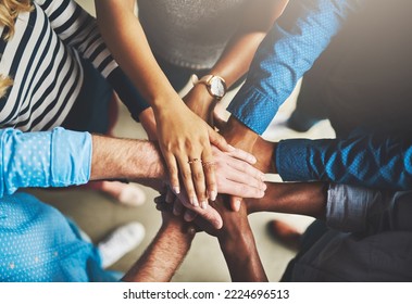 Getting it done through teamwork. Shot of a group of creative businesspeople standing with their hands in a huddle.