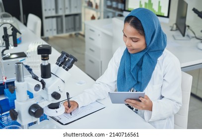 Getting Down To Life Enhancing Lab Work. Shot Of A Young Scientist Using A Digital Tablet While Conducting Research In A Laboratory.