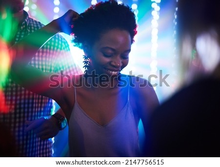 Getting down on the dance floor. Shot of a young woman dancing in a nightclub.
