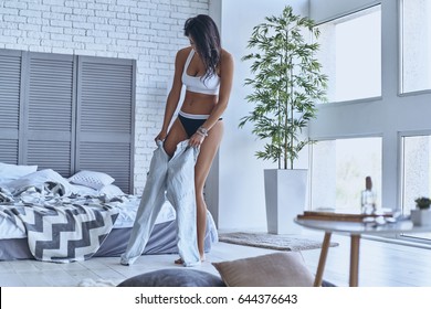 Getting Dressed. Full Length Of Beautiful Young Woman Getting Dressed While Standing In The Bedroom At Home