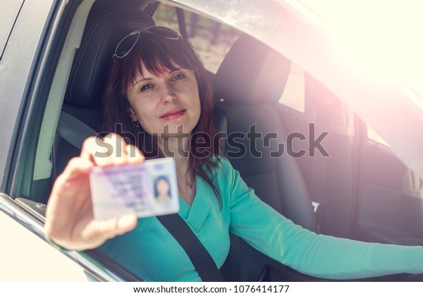 Getting a driver\'s\
license, a beautiful driving girl shows a new driver\'s license,\
Cars with left-hand\
traffic