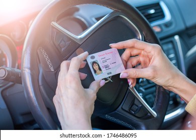 Getting a driver's license, female hands show US driving license, amid the steering wheel of a car - Shutterstock ID 1746486095