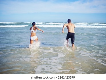 Getting Fit Together. A Couple Running At The Beach.