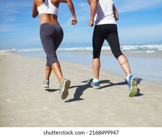 Getting Fit Together. A Couple Running At The Beach.