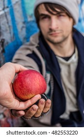 Getting Food. Kind Stranger Gives Apple To Homeless Man